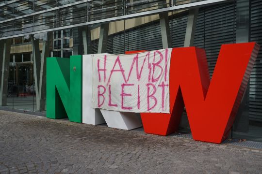 Ein Banner "Hambi bleibt" hängt über dem Schriftzug "NRW" aus großen freistehenden Buchstaben.