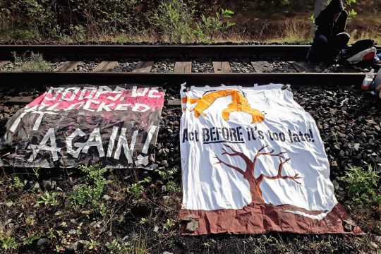 Protestplakate an der Hambachbahn, die von Aktivisten blockiert wird