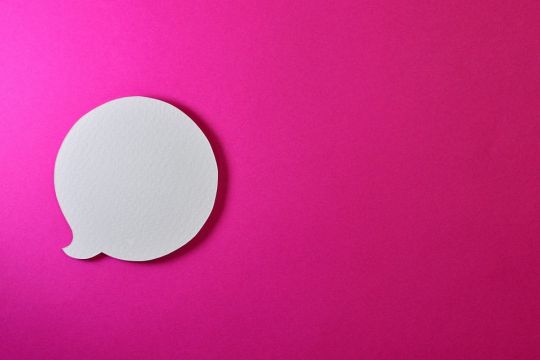 runde Sprechblase aus weißem Papier ausgeschnitten auf pinkem Untergrund
