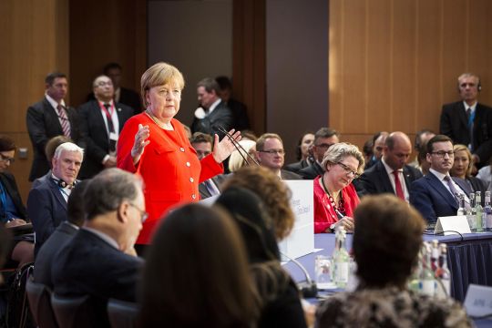 Bundeskanzlerin Angela Merkel redet vor einer kleineren Runde.