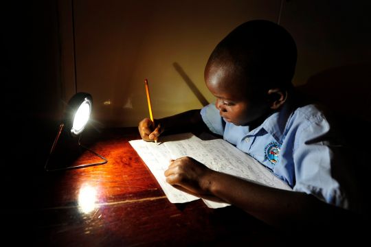 Ein Junge in Sambia lernt für die Schule mit einer Solar-Lampe