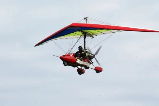 Ein Ultraleichtflugzeug im Daniel-Düsentrieb-Look fliegt durch die Luft.