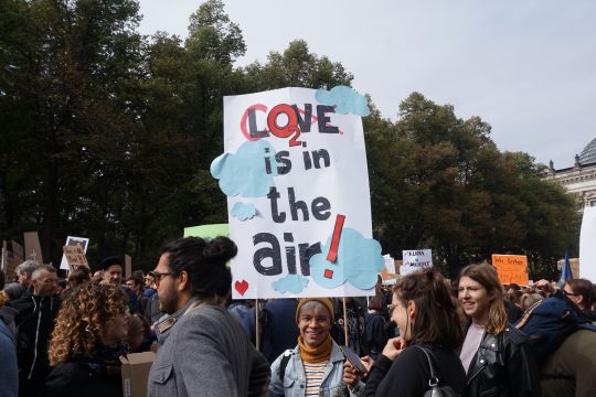 Demonstrierende mit Plakat "CO2 is in the air"