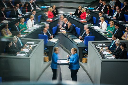Kanzlerin Merkel hält eine Rede im Bundestag, im Hintergrund ihr Kabinett