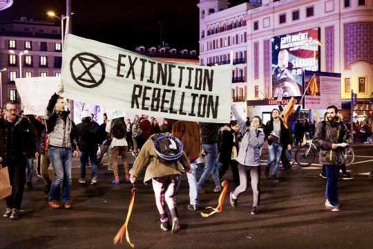 Aktivisten mit Extinction-Rebellion-Banner beim nächtlichen Protest