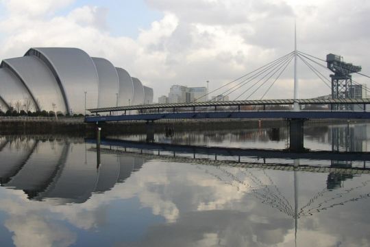 Das Glasgower Konferenzzentrum SEC, ein futuristischer Bau, spiegelt sich im Wasser.