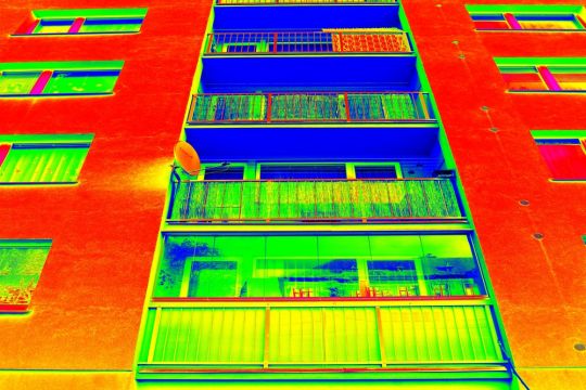 Thermografie-Aufnahme: Wärmeverluste an der Fassade eines Plattenbaus mit Loggien.