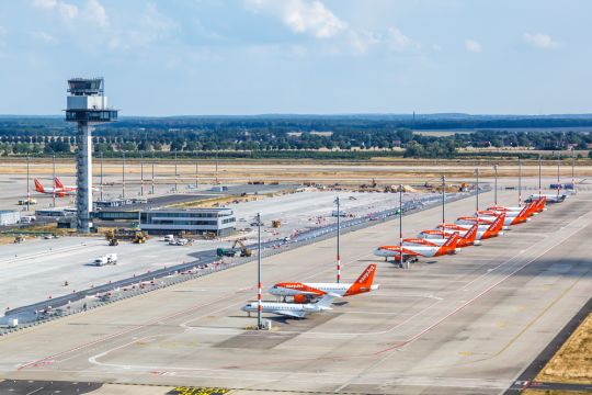Tower und Flugzeuge auf der riesigen betonierten Fläche des neuen Flughafens Berlin-Brandenburg.
