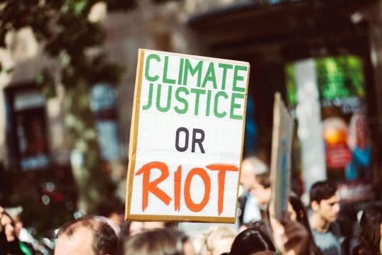 Schild mit der Aufschrift: Klimagerechtigkeit oder Aufstand.