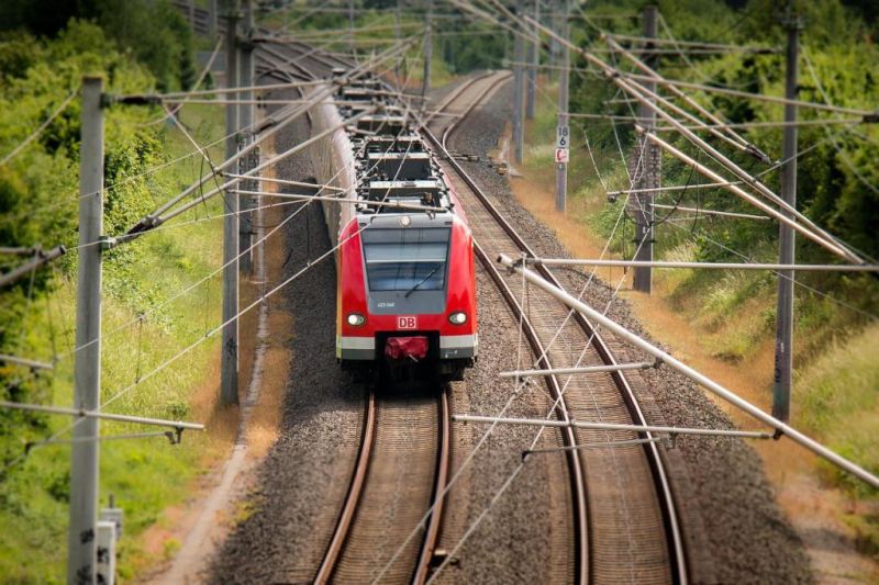 Roter Nahverkehrszug der Deutschen Bahn auf zweigleisiger, elektrifizierter Strecke, in einer leichten Kurve von vorne oben aufgenommen.