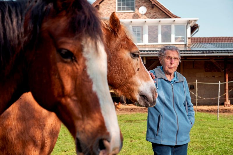 Die 86-jährige Marlene Kopp mit zwei Perden auf der Wiese an ihrem Haus.