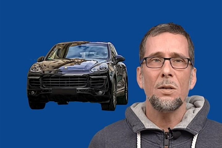Aufmacherbild: Volker Quaschning im grauen Kapuzenpulli vor blauem Hintergrund, neben ihm ein schwarzer SUV.