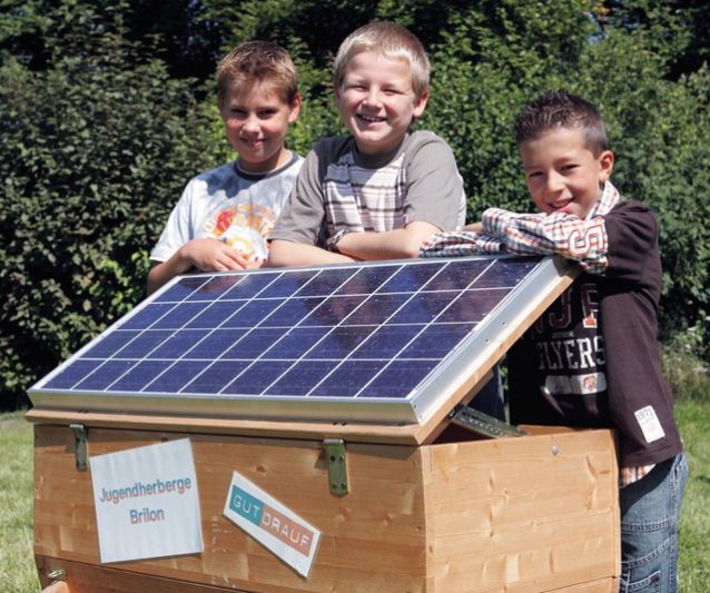 Kinder mit einem Solarmodul.