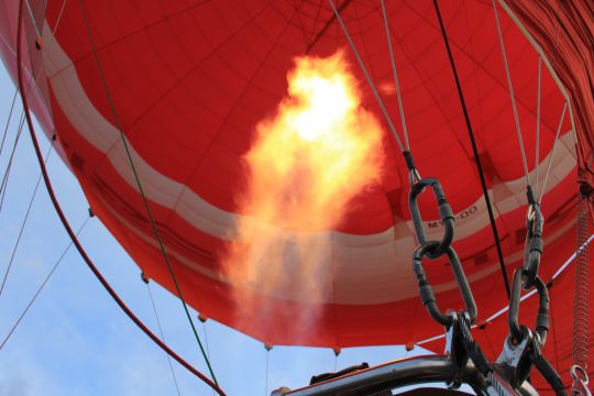 Symbolisch treibt ein Brenner einen Ballon nach oben