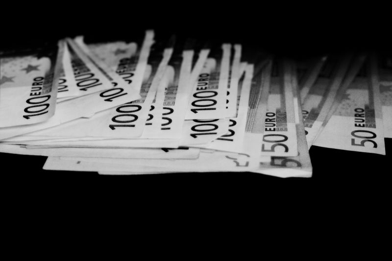 Euro-Geldscheine vor schwarzem Hintergrund.