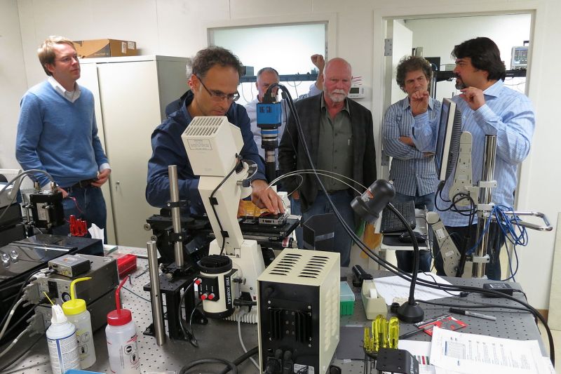 Sechs Genforscher stehen in einem Labor vor einigen kleineren Apparaturen.