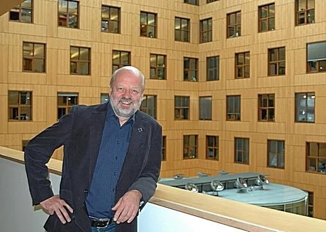 Hans-Josef Fell vor einer Innenhof-Fassade im Bundestag.