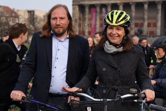Anton Hofreiter und Katrin Göring-Eckard (mit Helm) schieben Fahrräder durch eine Menschenmenge