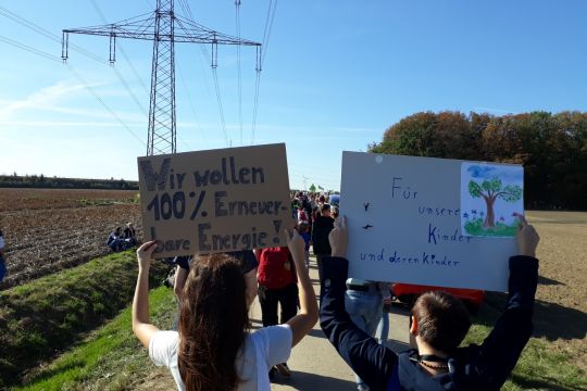 Menschen demonstrieren mit Schildern 