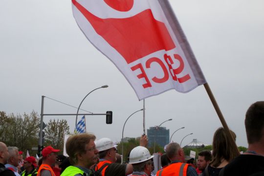 Demonstranten in Warnwesten, teils mit Schutzhelmen, und einer Flagge der IG BCE