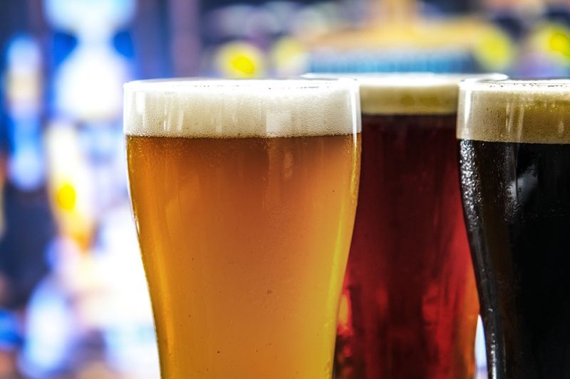 drei Gläser mit Bier vor unscharfem Hintergrund