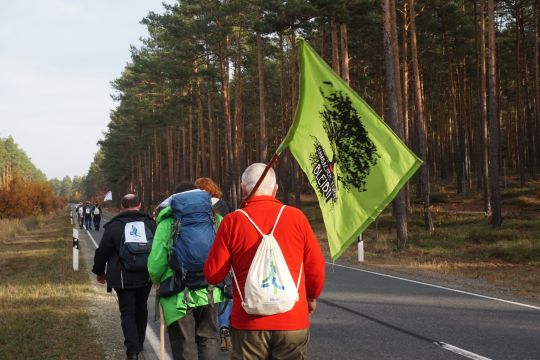 Die Klimapilger gehen an einer Landstraße entlang.