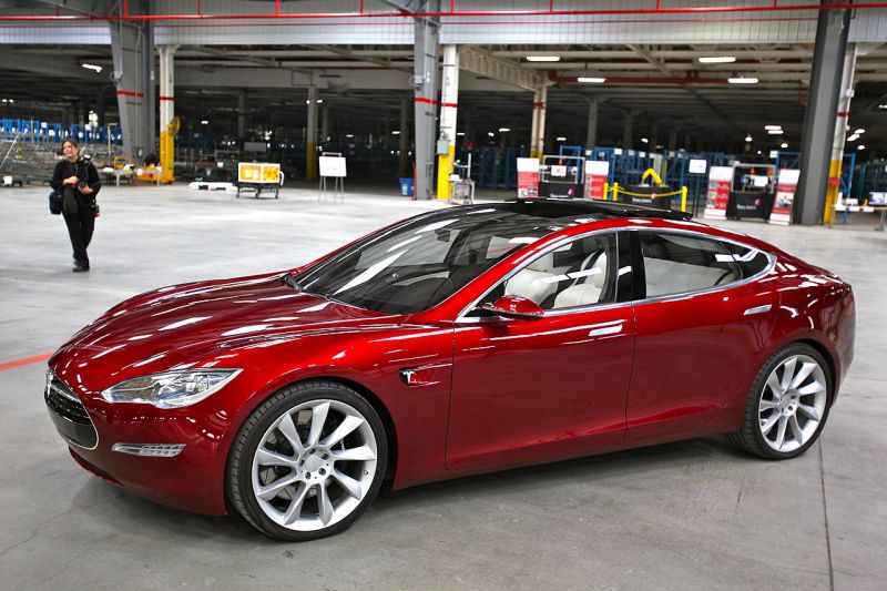 Ein rotes Auto der Marke Tesla Model S steht in einer Halle.
