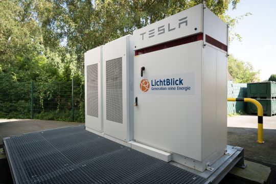 Ladesäule mit Unternehmensschriftzügen "Tesla" und "Lichtblick"