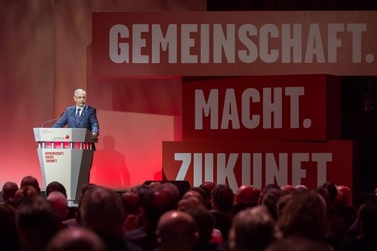 IC-BCE-Chef Vassiliadis redet vor einem riesigen Schriftzug "Gemeinschaft – Macht – Zukunft".