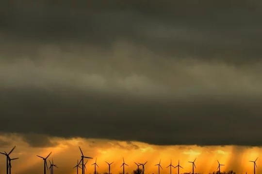 Windräder unter dunklen Regenwolken