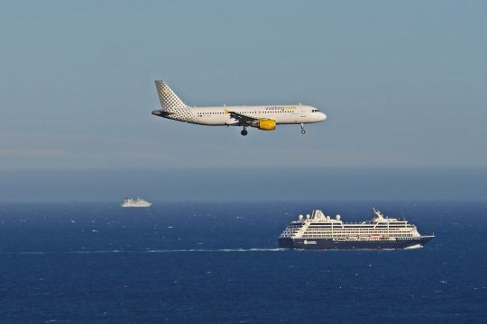 Ein Flugzeug und ein Kreuzfahrtschiff begegnen sich auf dem Meer.