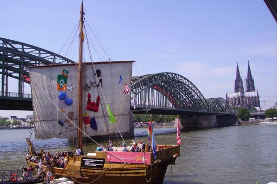 Der Nachbau einer Kogge aus dem 14. Jahrhundert mit evangelischen Kirchentagsbesuchern legt am Kölner Rheinufer neben der Hohenzollernbrücke an.