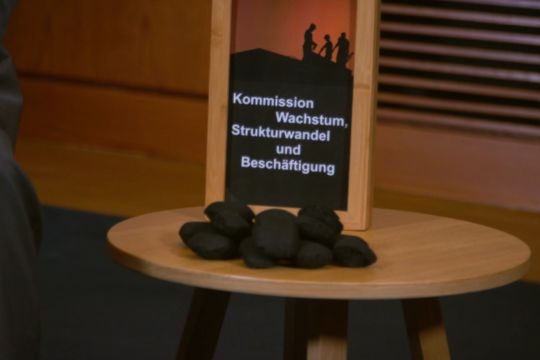 Einige Eierbriketts liegen auf einem Tisch, darauf ein Schild 