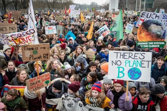 Große Masse an demonstrierenden jungen Menschen mit Schildern und Transparenten