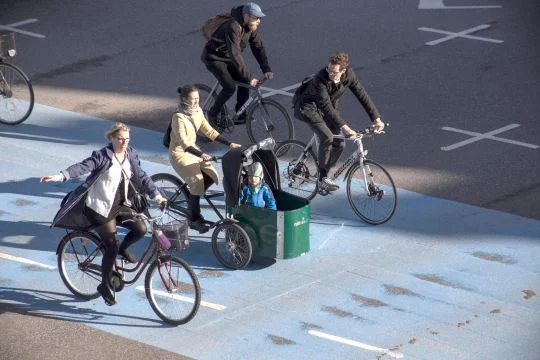 Fahrradfahrer in Kopenhagen überqueren eine Straßenkreuzung