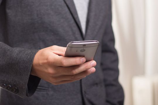 Ein Mensch tippt etwas in ein Smartphone ein.