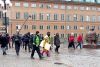 Greta Thunberg geht mit einem großen Schild bei regnerischem Wetter die Straße entlang.