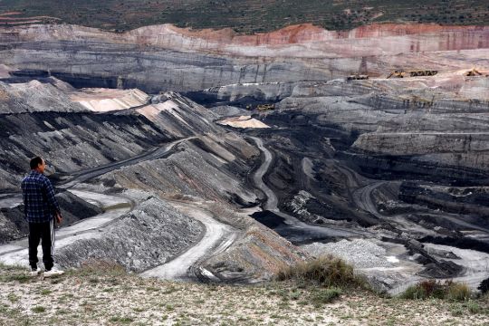 Ein Mann steht vor einem Braunkohletagebau im Aragon