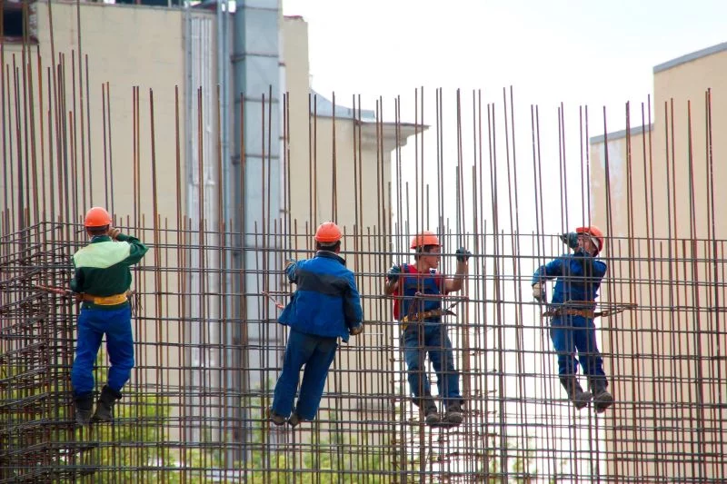 Vier Bauarbeiter arbeiten an einer Stahlbetonkonstruktion.