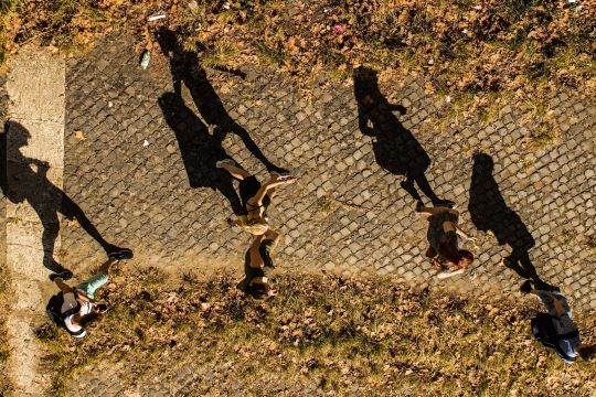 Symbolbild: Eine Gruppe gehender Menschen und ihre Schatten