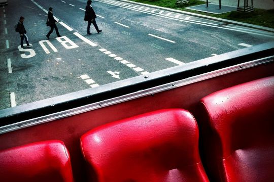 Blick aus einem Bus auf drei Fußgänger