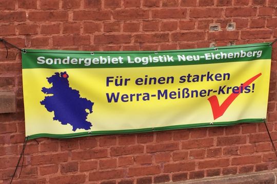 Gelb-grünes, professionell gefertigtes Transparent an einer Wand: