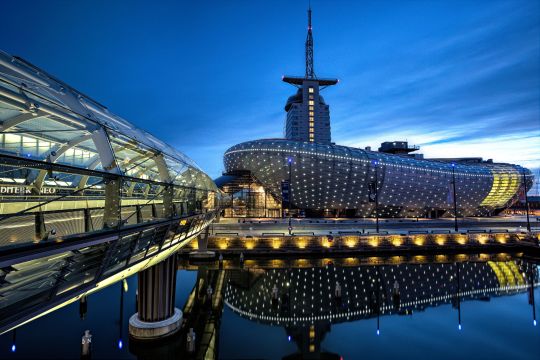 Das futuristisch wirkende Gebäude des Klimahauses Bremerhaven bei Nacht.
