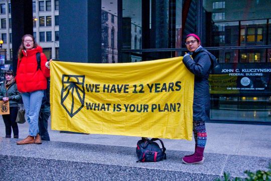 Aktivistinnen in Chicago halten ein gelbes Transparent: 