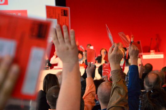 Hände mit Stimmkarten recken sich im Saal nach oben – alles in SPD-Rot.