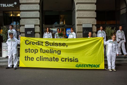 Aktivisten halten ein Plakat mit "Credit Suisse, stop fueling the climate crisis"