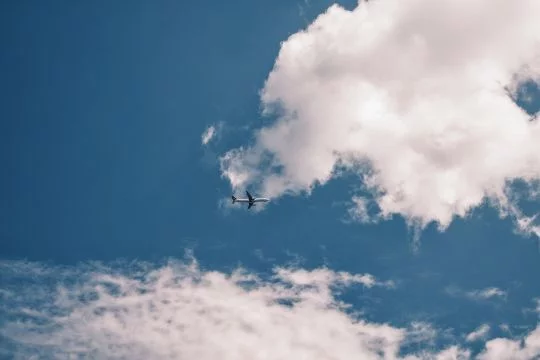 strahlend blauer Himmel, weiße Wolken und Flugzeug von unten
