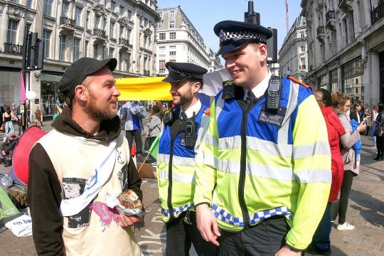 Extinction-Rebellion-Aktivist scherzt mit Polizisten: Dritter Tag der XR-Aktionstage im April 2019 am Oxford Circus in London.