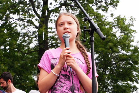 Greta Thunberg spricht auf einer Bühne.