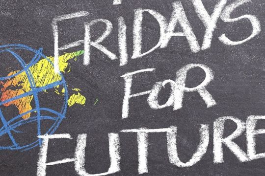 Auf eine schwarze Tafel ist mit Kreide eine Weltkugel gezeichnet, daneben steht: Fridays for Future.